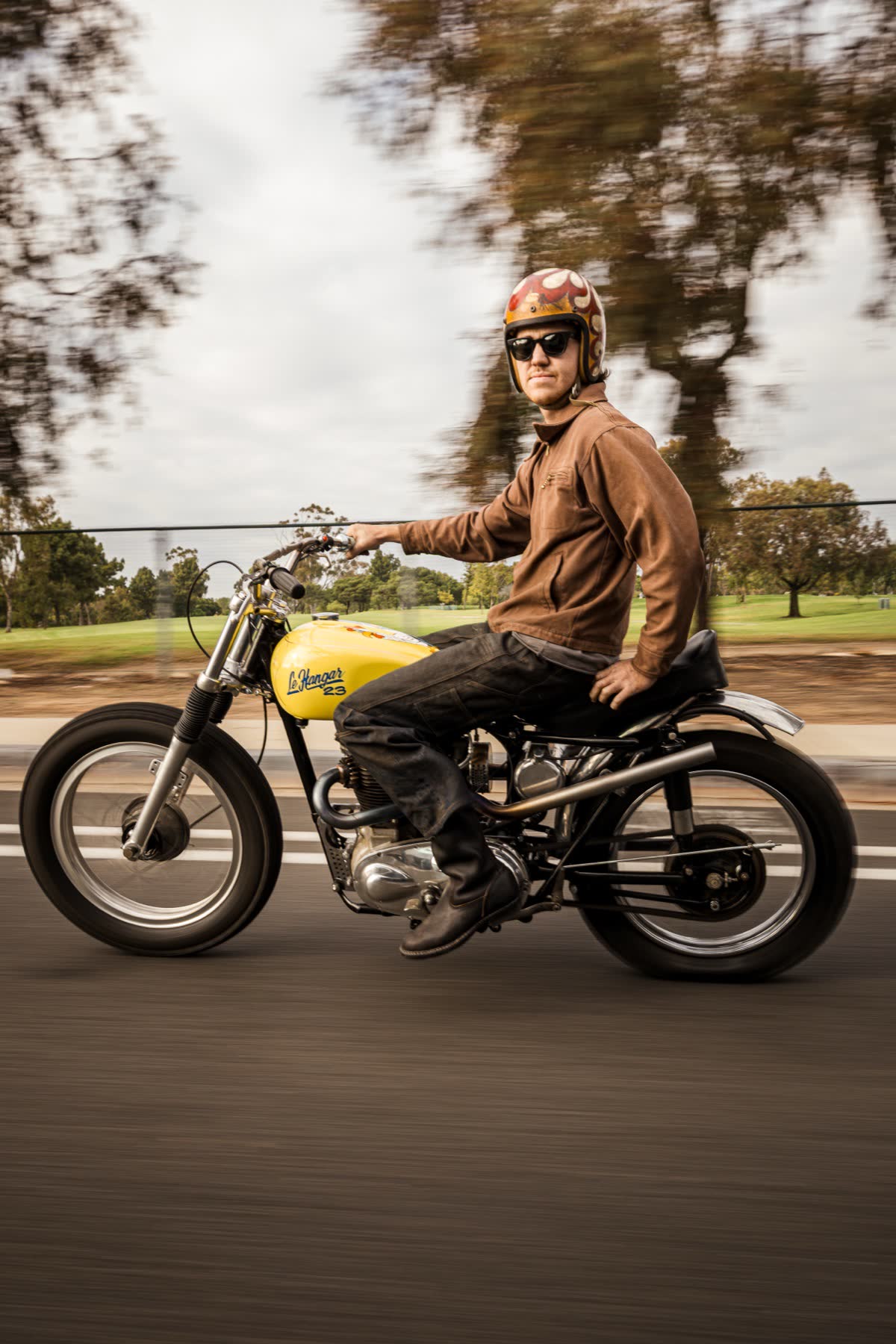 A rider on a yellow vintage Triumph in the open desert